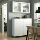 Salle à manger moderne avec armoire blanche et chaises en osier.