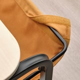 Gros plan de la pochette en tissu OLSERÖD sous la table, dotée d’une fermeture réglable pour le rangement.