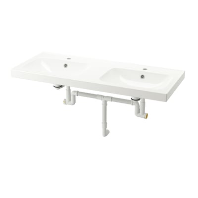Lavabos doubles en céramique blanche. Design moderne et rectangulaire avec drains intégrés et plomberie apparente.