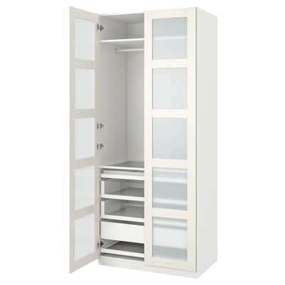Une armoire ikea PAX blanche avec des portes et des tiroirs en verre. Il a un design moderne et élégant.
