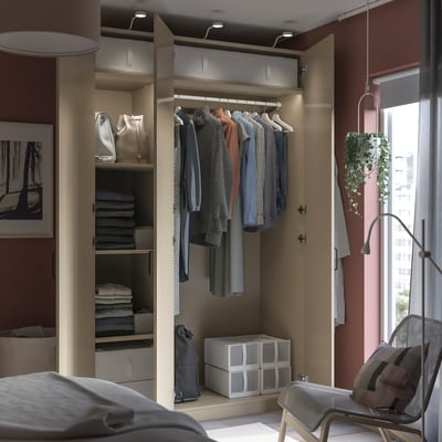 Dressing moderne avec des vêtements, des sacs suspendus et des boîtes de rangement.