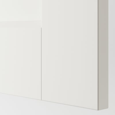 Une section d’une armoire PAX avec une finition lisse et blanche. La porte est un design épuré et moderne avec des poignées minimalistes.