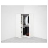 Une armoire PAX moderne, organisée avec des vêtements et des tiroirs dans une pièce minimaliste.