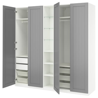 Une armoire PAX grise ouverte. Il dispose de tiroirs, d’étagères et de compartiments de rangement au design moderne.