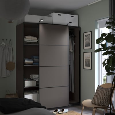 Chambre moderne avec armoire à porte coulissante grise, étagères et décoration.