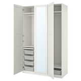 Armoire PAX blanche, ouverte, centre en miroir, étagères, tiroirs, paniers métalliques.