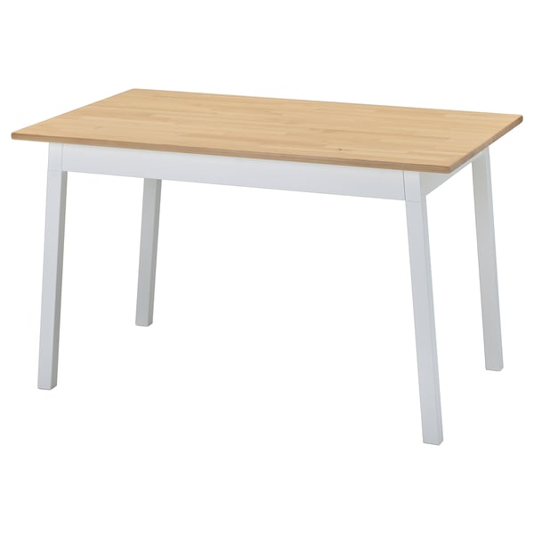 Table à manger en bois nommée PINNTORP, peut accueillir quatre personnes, pieds blancs, plateau en bois naturel. Style scandinave.