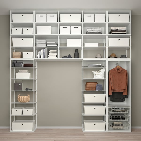 Étagères blanches bien organisées avec divers compartiments, y compris des boîtes, des livres, des vêtements et des accessoires, maximisant efficacement l’espace de stockage.