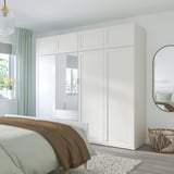 Armoire PLATSA avec miroirs, à côté du lit, du miroir et du panier.