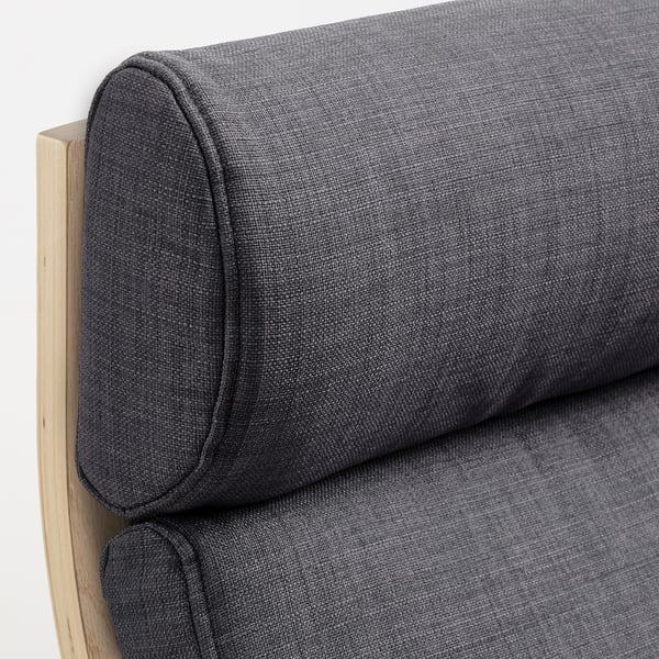 Gros plan d’une chaise rembourrée en peluche gris foncé, mettant en valeur sa texture douce et son cadre en bois.