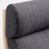Gros plan d’une chaise rembourrée en peluche gris foncé, mettant en valeur sa texture douce et son cadre en bois.