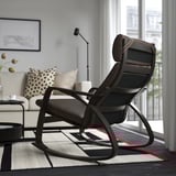 Salon : chaise berçante près de la fenêtre, canapé blanc, table d’appoint avec lampe et fleurs, tapis rayé, tableau mural.