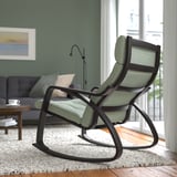 Chaise berçante verte moderne près de la fenêtre avec cadre noir et coussin confortable.