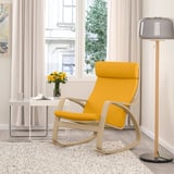 Chaise berçante POÄNG jaune vif avec cadre en bois clair près d’une grande fenêtre, entourée d’un décor minimaliste.