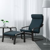 Salon minimaliste avec fauteuil POÄNG bleu et repose-pieds assorti. Décor neutre avec tapis et table d’appoint gris, plante et grand lampadaire.
