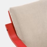 Fauteuil rouge avec coussin beige d’ikea POÄNG, moelleux et confortable.