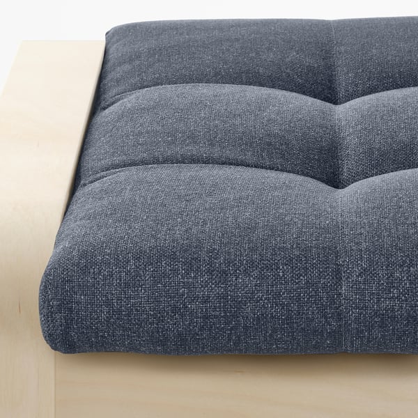 Gros plan d’un repose-pieds rembourré au design capitonné, mettant en valeur un savoir-faire de qualité et un tissu confortable et durable.