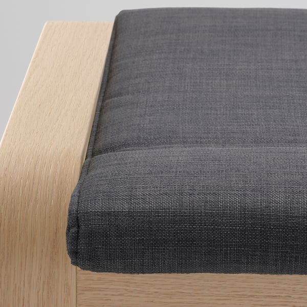 Gros plan d’un repose-pieds moderne et élégant avec un tissu lisse et un cadre en bois robuste, mettant en valeur un design et un savoir-faire de qualité.