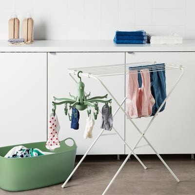 Cintre PRESSA en forme de pieuvre, blanc, pour ranger vêtements et chaussettes. Se pose sur un support, s’adapte près du panier vert.