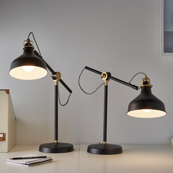 Deux lampes de bureau RANARP avec des accents en laiton et une lumière chaude.