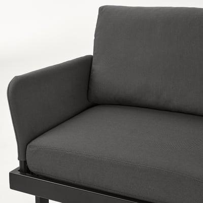Ensemble de meubles d’extérieur modernes avec un cadre en métal noir et des coussins gris foncé, mettant en valeur des lignes épurées et une construction robuste.
