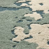 Tapis abstrait avec mélange de poils hauts/bas. Matériaux doux et respectueux de l’environnement. Nuages blanc cassé sur fond vert.