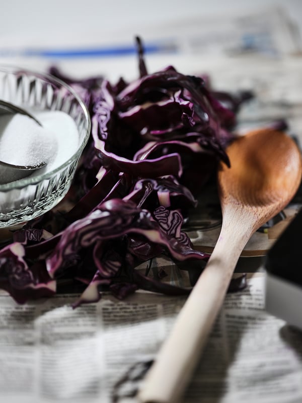 Chou violet tranché, sucrier, cuillère en bois sur la table.