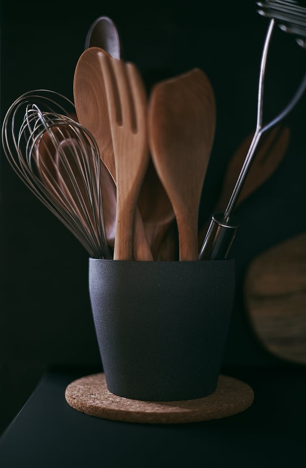 Porte-ustensiles RÖRT noir avec outils en bois, fouet en fil, base solide.
