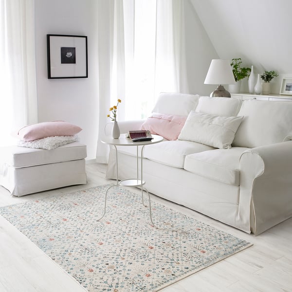 Tapis floral ROMDRUP dans le salon avec canapé, ordinateur portable, vase.