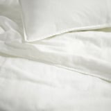Ensemble de draps de lit blanc impeccable, prélavé, texture lisse, tissu de qualité.