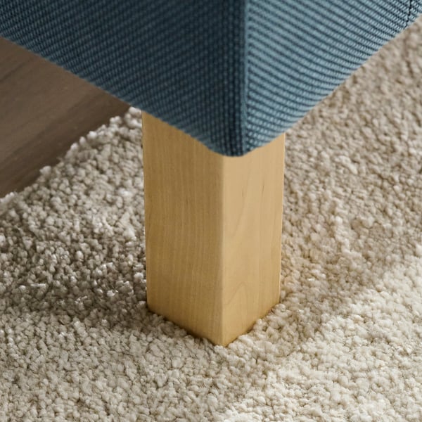 Un canapé moderne au design élégant, avec des pieds en bois robustes et un tissu en tissu texturé confortable.