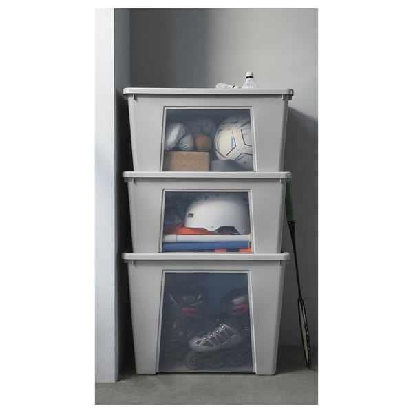 Trois boîtes de rangement SAMLA grises empilées avec des côtés transparents, pour stocker du matériel de sport.