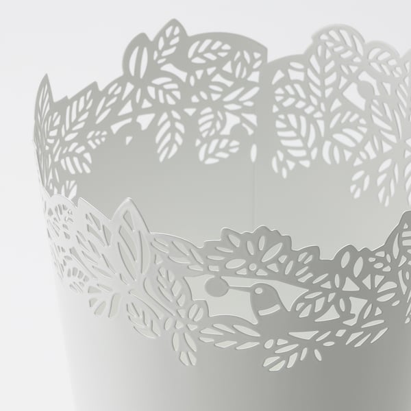 Motif feuillu complexe sur jardinière blanche, fabriqué avec précision.