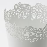 Motif feuillu complexe sur jardinière blanche, fabriqué avec précision.