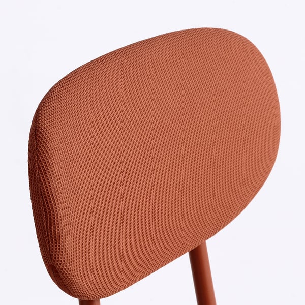 Gros plan du dossier d’une chaise rembourrée dans un tissu texturé, mettant en valeur son design et sa qualité.