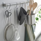 Organisateur de cuisine avec ustensiles suspendus, gant et passoire.