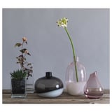 Vases SANNOLIK en verre noir, rose et transparent. Différentes formes et tailles sont affichées sur une surface en bois.