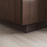 Armoire en bois foncé avec une base de socle noire élégante, donnant un look moderne.