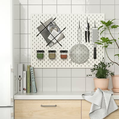 Panneau perforé de cuisine avec des ustensiles de cuisine, des casseroles et des plantes. Organisé avec les accessoires SKÅDIS.