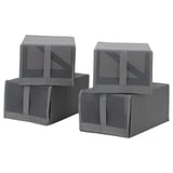 Quatre boîtes en tissu gris avec des dessus en filet, des poignées et des fermetures éclair, soigneusement empilées dans un arrangement compact et rectangulaire.