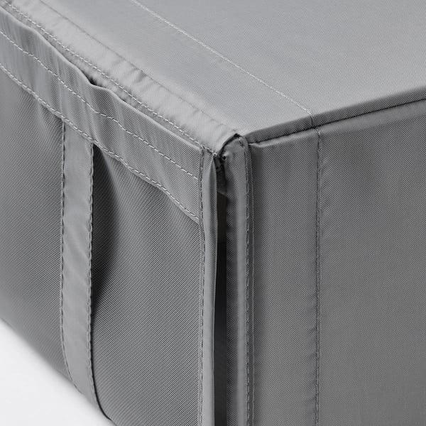 Gros plan de la boîte de rangement en maille grise, mettant en valeur les coutures durables et les détails de la fermeture éclair.