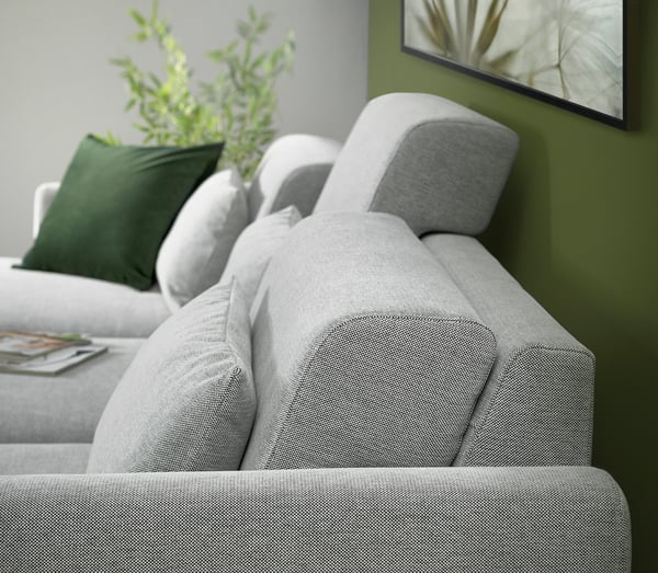 Salon moderne avec canapé sectionnel SLATORP gris, oreillers vert foncé et télévision à écran plat. Plantez sur la table d’appoint.