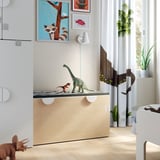 Chambre d’enfant avec banc de jouet SMÅSTAD, blanc. Jouets de dinosaures, impressions d’art, parquet en bois clair, plantes.