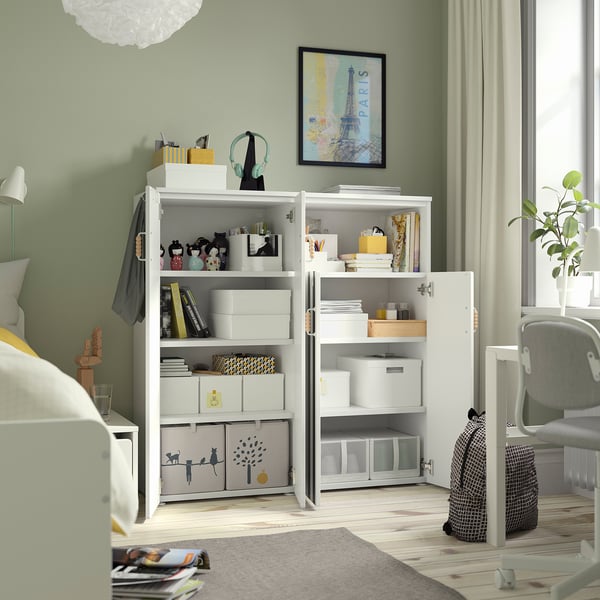 Chambre avec unité de rangement SMÅSTAD montrant des étagères ouvertes remplies de boîtes et d’articles de rangement.