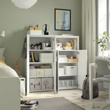 Chambre avec unité de rangement SMÅSTAD montrant des étagères ouvertes remplies de boîtes et d’articles de rangement.