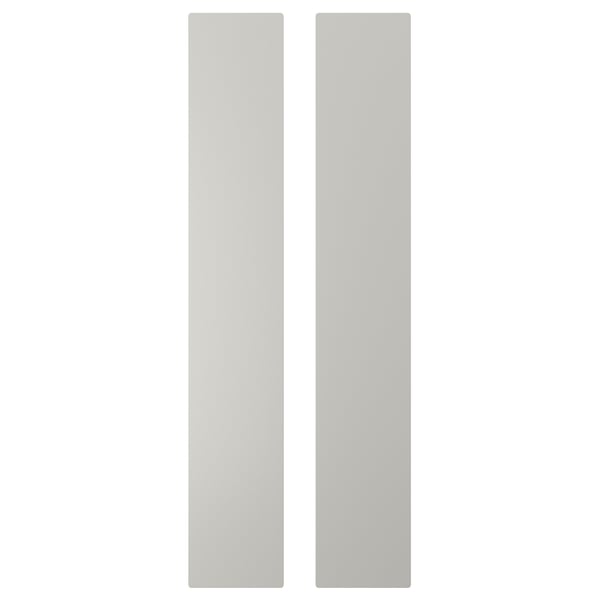 Deux panneaux rectangulaires verticaux blancs, faisant partie d’une unité de rangement pour enfants, fabriqués à partir de panneaux de fibres aux coins arrondis.