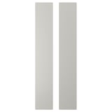 Deux panneaux rectangulaires verticaux blancs, faisant partie d’une unité de rangement pour enfants, fabriqués à partir de panneaux de fibres aux coins arrondis.