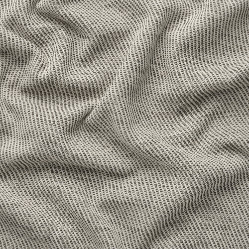 Un gros plan d’un tissu tissé texturé, blanc grisâtre, avec un toucher doux et durable, probablement à partir d’une housse de canapé.