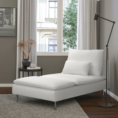 Chaise longue blanche moderne avec pieds noirs dans une chambre minimaliste.