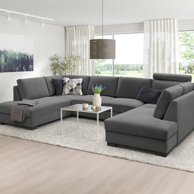 Canapé SÖRVALLEN gris moderne en forme de U, grande taille, parquet clair, tapis blanc, grandes fenêtres, décor minimaliste.